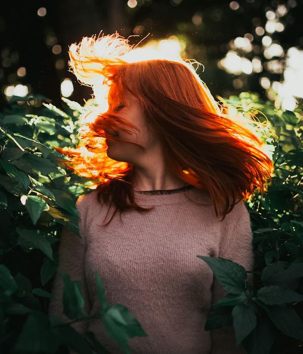 Woman performing a light, dynamic movement in a serene environment.